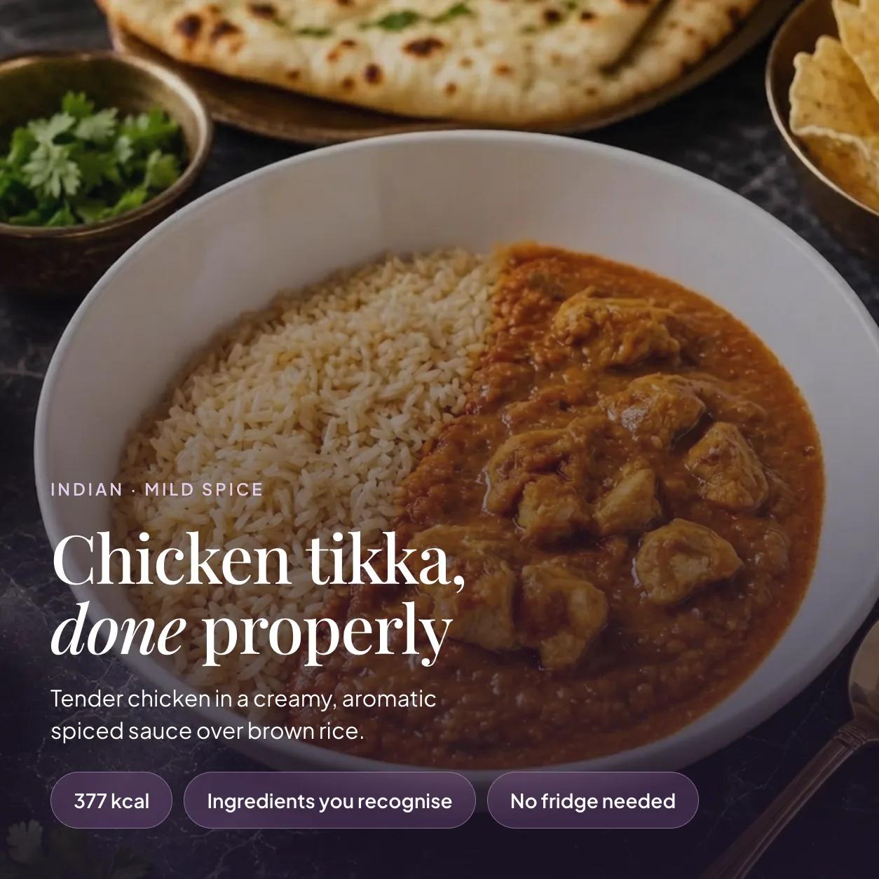 Bowl of EatProtein chicken tikka ready meal with tender chicken in a creamy spiced sauce over brown rice — 377 kcal, no fridge needed
