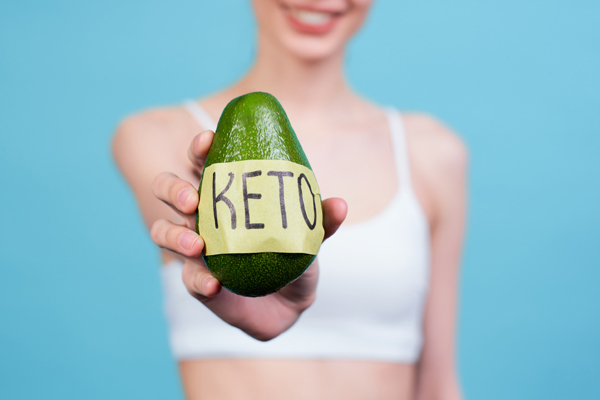 Woman holding half a fresh avocado