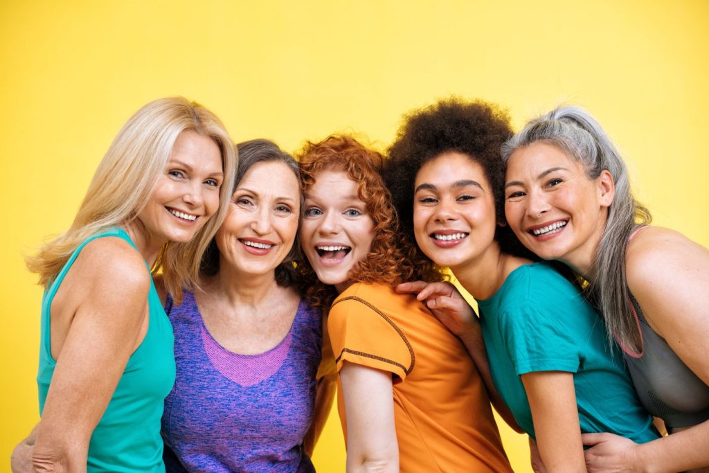 Group of smiling women friends with their arms around each other