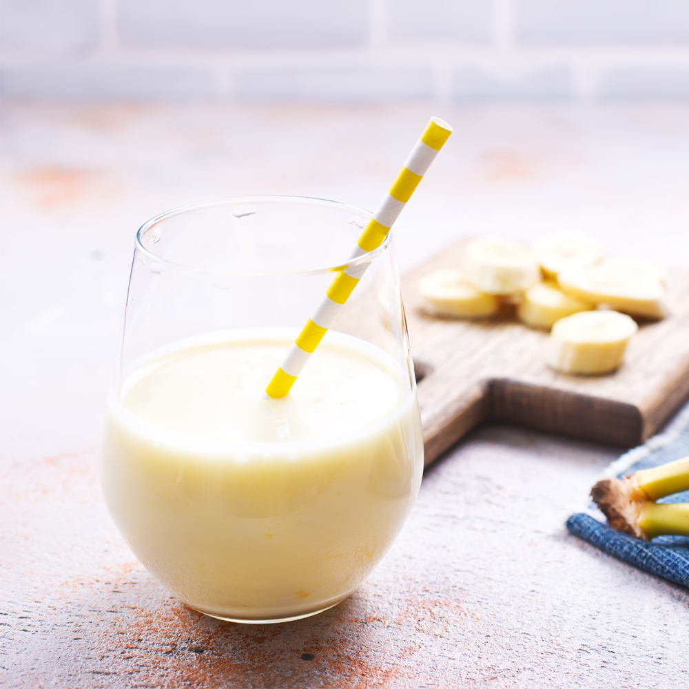 A prepared meal replacement shake in a plain glass on a kitchen worktop
